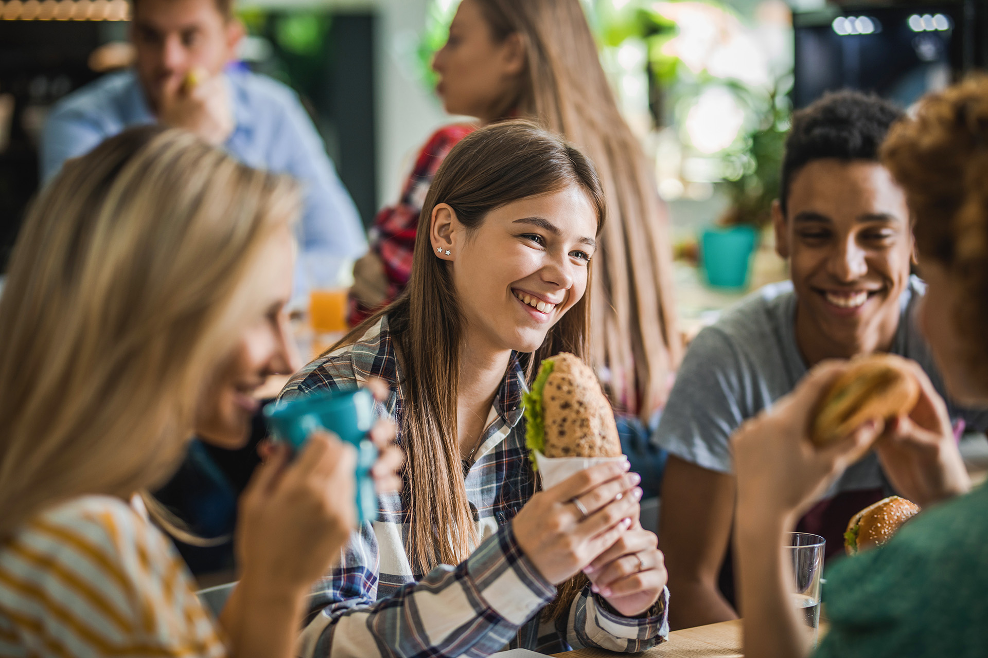 Group of school children eating healthy sandwiches