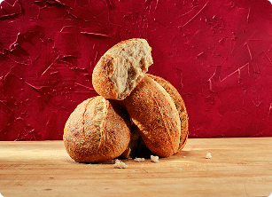 Torn country white sourdough loaves on a wooden board