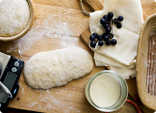 Shaped sourdough dough resting beside a jar of starter