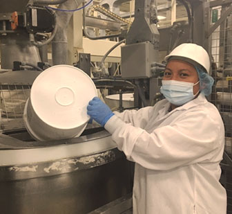 employee wearing mask mixing ingredients