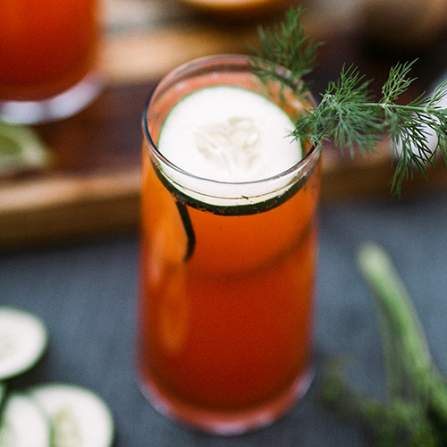 Dill Paloma cocktail with a cucumber floating on top