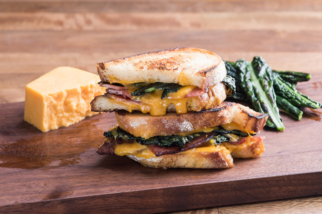 Ham and cheese panini sliced and stacked on wood background