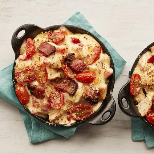 Two cooked hot browns in single serving cast iron pots