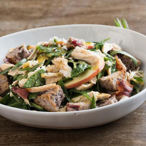 Chicken Salad Recipe completed in a white bowl on wooden counter