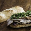 Sliced Demi French Baguette Porchetta Sandwich with greens