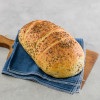 Whole New York Rye Loaf artisan bread on blue towel and wood serving board