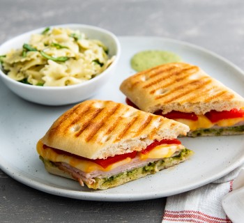 SlicedFocaccia Turkey Pesto Aioli Panini Sandwich on white plate