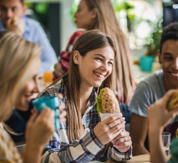 Group of school children eating healthy sandwiches