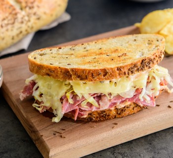 Reuben sandwich with New York rye artisan bread on wooden cutting board