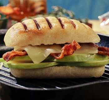 Apple, gruyere and bacon panini on Ciabatta roll bread with black cast iron serving plate